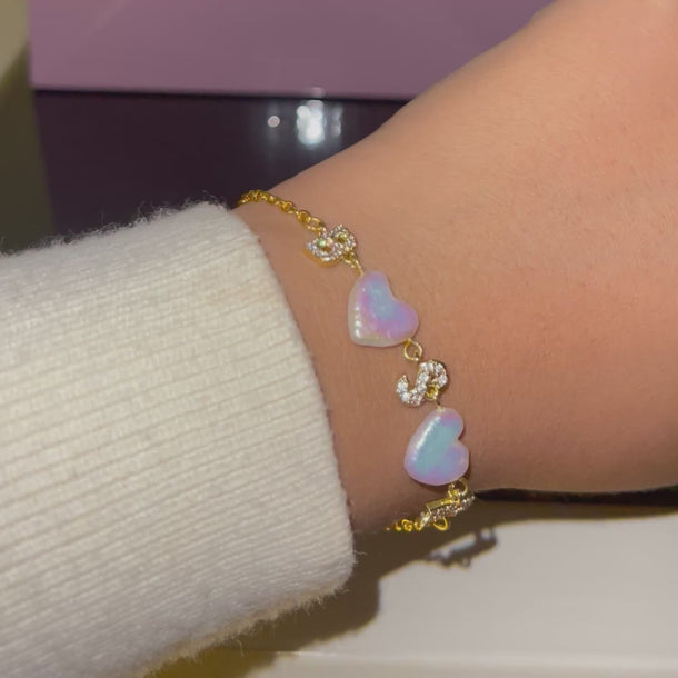 18k gold-plated bracelet with heart-shaped freshwater pearls on a wrist against a neutral background